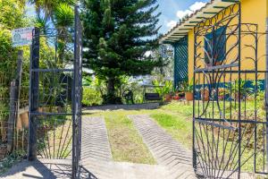 a gate to a garden with a house in the background at FINCA COCUYAL...todo un pesebre VIVO! in Rionegro