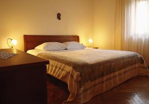 a bedroom with a bed with two lamps and a desk at Apartments by the sea Postira, Brac - 9241 in Postira
