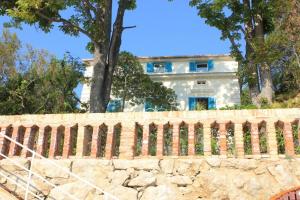 a house behind a stone wall with a fence at Family friendly seaside apartments Moscenicka Draga, Opatija - 9242 in Mošćenička Draga