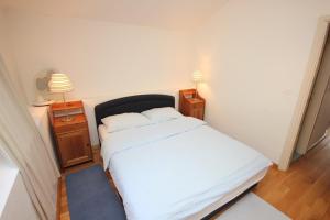 a small bedroom with a bed and two night stands at Family friendly seaside apartments Moscenicka Draga, Opatija - 9242 in Mošćenička Draga