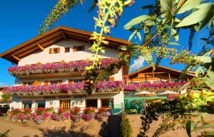a building with flowers on the side of it at Hotel Garni Doris in Castelrotto