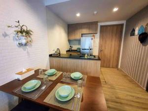 Ban Bo Talung (2)Rain Condo @ Cha Am-Huahin, Pool Access from room的厨房配有木桌和盘子