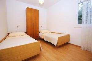 a bedroom with two beds and a window at Apartment Prizba 9255b in Prizba