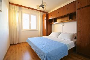 a bedroom with a blue bed and a window at Apartments by the sea Prizba, Korcula - 9255 in Prizba