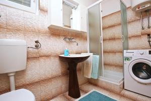 a bathroom with a sink and a washing machine at Apartments by the sea Prizba, Korcula - 9255 in Prizba