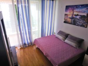 Apartments with a parking space Icici, Opatija - 7859 في إيتْشيتْشي: غرفة نوم بسرير ارجواني ونافذة
