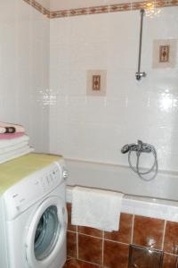Apartments with a parking space Icici, Opatija - 7859 في إيتْشيتْشي: حمام مع غسالة في حوض الاستحمام