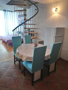 Apartments with a parking space Icici, Opatija - 7859 في إيتْشيتْشي: غرفة طعام مع طاولة وكراسي ودرج