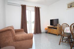 - un salon avec un canapé et une télévision dans l'établissement Apartments for families with children Kastel Stafilic, Kastela - 9211, à Kaštela