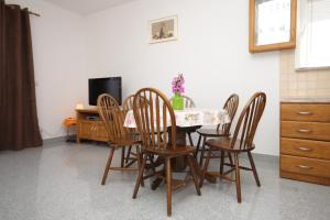 une salle à manger avec une table, des chaises et une télévision dans l'établissement Apartments for families with children Kastel Stafilic, Kastela - 9211, à Kaštela