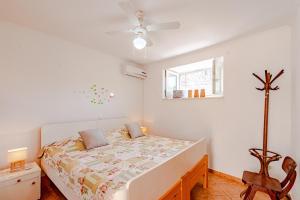 a white bedroom with a bed and a window at Apartments with a parking space Zrnovo, Korcula - 9239 in Korčula