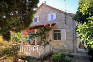 a stone house with a balcony in front of it at Seaside holiday house Brna, Korcula - 9235 in Smokvica