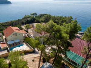 an aerial view of a house with a swimming pool and the ocean at Seaside family friendly house with a swimming pool Brna - Vinacac, Korcula - 9266 in Prizba