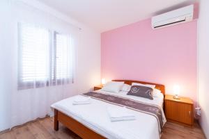 una camera da letto con un letto con lenzuola bianche e una finestra di Seaside family friendly house with a swimming pool Brna - Vinacac, Korcula - 9266 a Prižba
