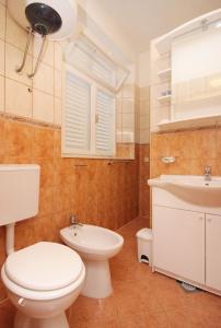 a bathroom with a toilet and a sink at Seaside holiday house Brna, Korcula - 9235 in Smokvica
