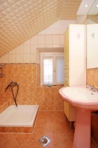 a bathroom with a sink and a bath tub at Seaside holiday house Brna, Korcula - 9235 in Smokvica