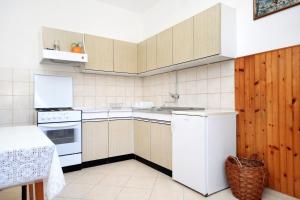 a small kitchen with white appliances and a table at Apartments by the sea Medvinjak, Korcula - 9268 in Korčula