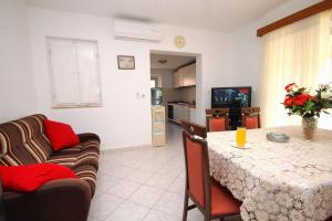 a living room and kitchen with a table and a couch at Family friendly apartments with a swimming pool Smokvica, Korcula - 9161 in Smokvica