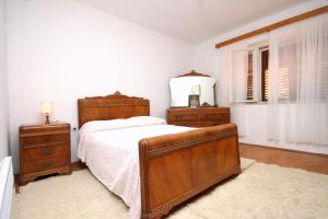 a bedroom with a bed and two dressers and a mirror at Family friendly apartments with a swimming pool Smokvica, Korcula - 9161 in Smokvica +24 photos
