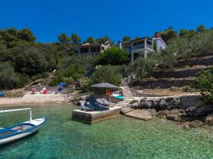 a house on a hill with boats in the water at Seaside house for families with children Cove Stratincica, Korcula - 9265 in Vela Luka