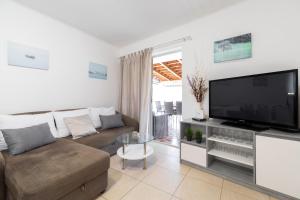 a living room with a couch and a large flat screen tv at Seaside house for families with children Cove Stratincica, Korcula - 9265 in Vela Luka