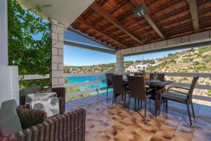 a patio with a table and chairs and a view of the water at Seaside house for families with children Cove Stratincica, Korcula - 9265 in Vela Luka