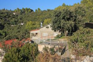 a building on the side of a hill with trees at Apartments by the sea Cove Stratincica, Korcula - 9264 in Vela Luka