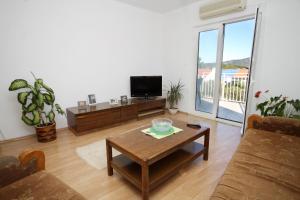 a living room with a coffee table and a tv at Apartments by the sea Kneza, Korcula - 9164 in Pupnat