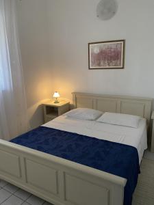 a bedroom with a bed with a blue blanket at Apartments by the sea Cove Stratincica, Korcula - 9264 in Vela Luka