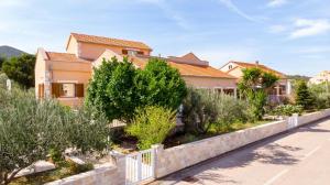 a house with a fence and trees and bushes at Apartments by the sea Kneza, Korcula - 9168 in Račišće