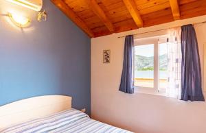 a bedroom with a bed and a window at Apartments by the sea Kneza, Korcula - 9168 in Račišće