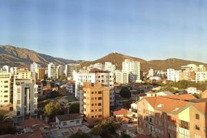 uma cidade com edifícios e montanhas ao fundo em Monoambiente de Lujo en EL PRADO de Cochabamba II em Cochabamba