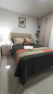 um quarto com uma cama grande e uma mesa de cabeceira em Monoambiente de Lujo en EL PRADO de Cochabamba II em Cochabamba