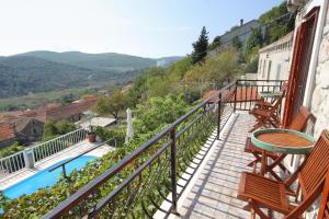 einen Balkon mit Stühlen, einem Tisch und einem Pool in der Unterkunft Holiday house with a swimming pool Smokvica, Korcula - 9297 in Smokvica