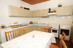 a kitchen with a table and a white table and chairs at Holiday house with a parking space Zrnovo, Korcula - 9213 in Korčula