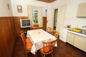 a kitchen with a table and chairs and a television at Holiday house with a parking space Zrnovo, Korcula - 9213 in Korčula