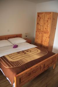 sypialnia z dużym łóżkiem z drewnianą ramą w obiekcie Apartments by the sea Kneza, Korcula - 9166 w mieście Pupnat