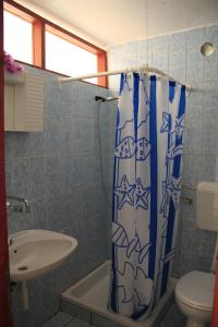 łazienka z zasłoną prysznicową i umywalką w obiekcie Apartments by the sea Kneza, Korcula - 9166 w mieście Pupnat