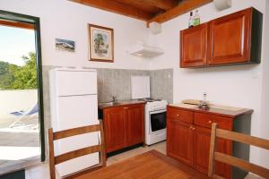 cocina con armarios de madera y horno de fogón blanco en Apartments with WiFi Zrnovo, Korcula - 9214, en Korčula