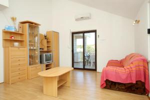 a bedroom with a bed and a table in a room at Apartments by the sea Kneza, Korcula - 9185 in Račišće