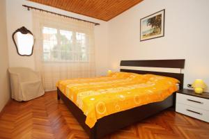 a bedroom with a bed with a yellow bedspread at Apartments by the sea Brna, Korcula - 9296 in Smokvica