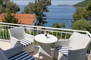 a balcony with a table and chairs and the ocean at Apartments by the sea Brna, Korcula - 9296 in Smokvica