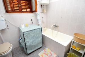 uma casa de banho com uma banheira, um WC e um lavatório. em Apartments and rooms by the sea Lumbarda, Korcula - 9272 em Lumbarda