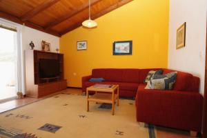 a living room with a red couch and a tv at Apartment Kneza 9171a in Pupnat