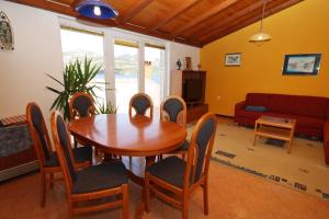 a living room with a wooden table and chairs at Apartment Kneza 9171a in Pupnat