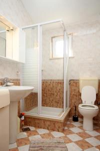 a bathroom with a shower and a toilet and a sink at Apartments by the sea Kneza, Korcula - 9171 in Pupnat