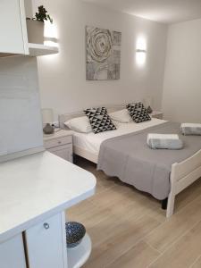 a white room with two beds and a table at Seaside apartments with a swimming pool Lumbarda, Korcula - 9303 in Lumbarda +42 photos