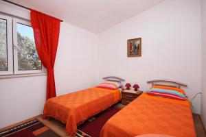 a bedroom with two beds and a window at Apartments by the sea Brna, Korcula - 9231 in Smokvica