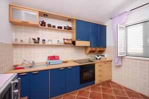 a kitchen with blue cabinets and a sink at Apartments by the sea Brna, Korcula - 9231 in Smokvica