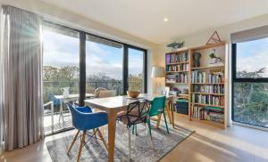 a dining room with a table and chairs and a book shelf at Lovely Luminous 3 Bed Flat, with secure Ev Parkng in London